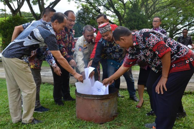 Yustinus Giri Staf Ahli Bupati (dua kanan) bersama Kepala Diarpus Kubar Yosef Stevenson (kiri) melakukan pemusnahan arsip dengan cara dibakar secara simbolis, di Halaman Gedung Depo Arsip Kubar, Barong Tongkok.