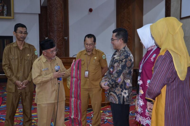 Asisten 2 Sekkab Kubar Rakhmat (dua kiri) didampingi Kabag Organisasi Sekkab Kubar Agung Sugara (kiri) menyerahkan cenderamata selendang doyo kepada nara sumber dari BKN Pusat, seusai membuka pelatihan penyusunan Anjab dan ABK, di ATJ, Kantor Bupati Kubar.