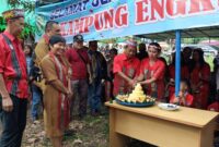 Petinggi Kampung Engkuni Pasek Bersama Istri Saat Melakukan Pemotongan Tumpeng HUT ke-66.
