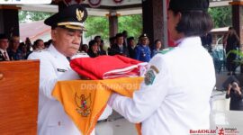 Caption : Foto Wakil Bupati Mahakam Ulu, Drs Yohanes Avun Saat Memimpin Upacara Penurunan Bendera Peringatan HUT ke-80 RI Berlangsung dengan Khidmat.