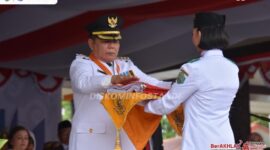 Foto Caption : Bupati Mahulu Bonifasius Belawan Geh Saat Menyerahkan Sang Saka Merah Putih untuk dikibarkan pada Upacara Peringatan HUT ke-80 RI.