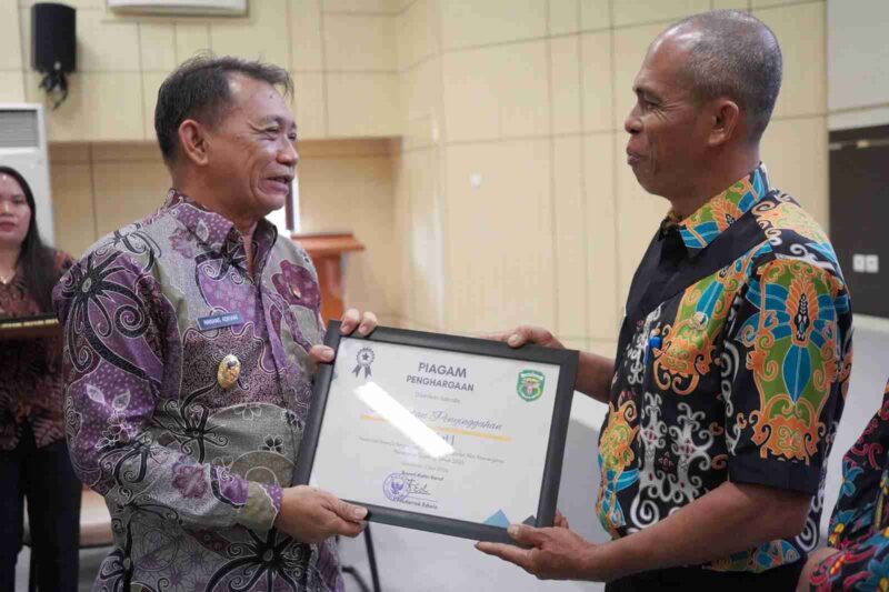 Foto Wakil Bupati Kutai Barat, H.Nanang Adriani Saat Menyerahkan Piagam Penghargaan Kepada Bahrin Selaku Kasi Pendidikan dan Kesehatan Kecamatan Penyinggahan Atas Prestasi Percepatan Penurunan Stunting.